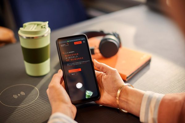Holding a phone with the Club Avanti app