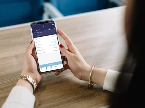 Woman holding a phone with a train booking app
